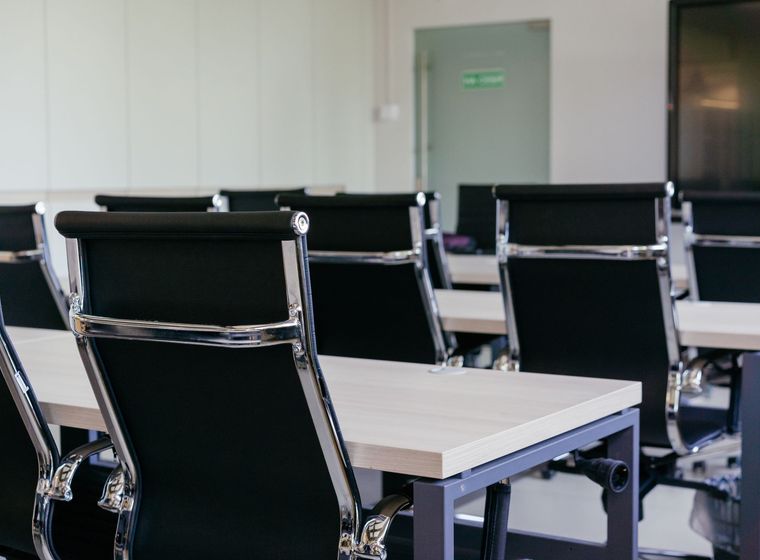A pristine corporate boardroom with a long table ready for the working day