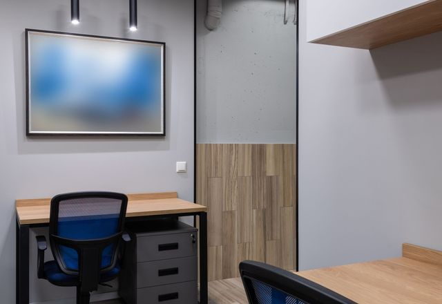 A bright open-plan corporate office with rows of clean workstations