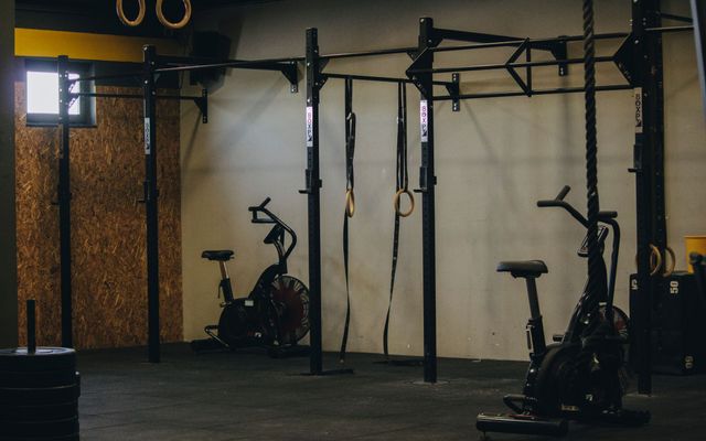 A clean, modern gym floor with equipment arranged and mirrors polished