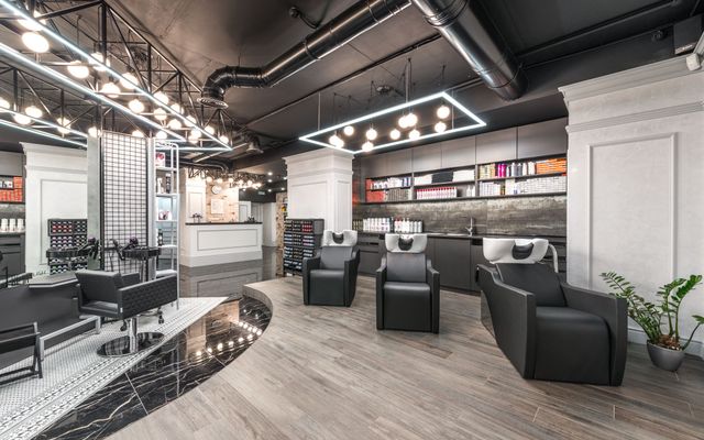 A clean, elegant beauty salon interior with chairs and mirrors