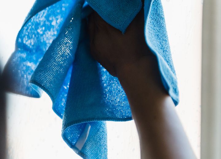A neatly folded blue cleaning towel held ready for a housekeeping visit